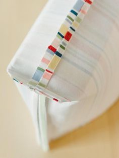 a close up of a folded napkin on top of a white plate with a red, green, blue and yellow stripe