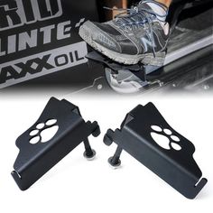 pair of black footrests with paw prints on the front and back of a vehicle