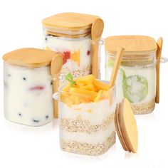 four jars filled with different types of food and wooden spoons next to each other