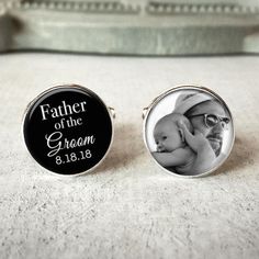 two cufflinks with an image of a man holding a baby and the words father of the groom on them