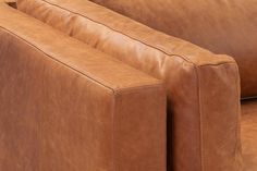 a brown leather couch sitting on top of a wooden table