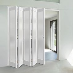 the room divider is open to reveal an empty living area with white walls and doors