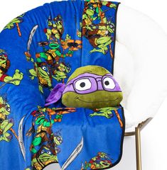 a chair that has a pillow on it with teenage mutant characters all over the back