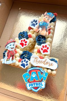 there is a cake in the shape of a letter with paw patrol decorations on it