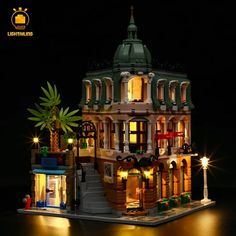 a lego lit up building with people standing around it