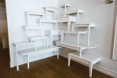 several white shelves and benches in a room