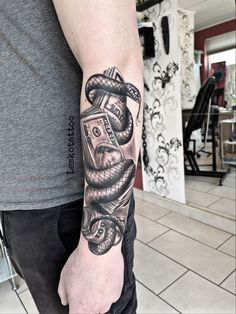 a man with a snake and money tattoo on his arm