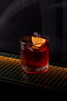 an orange slice sitting on top of a glass filled with liquid