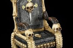 a skeleton chair with two skulls on it's legs and a knife sticking out of the back