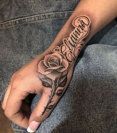 a person's hand with a rose and the word grandma tattooed on it in cursive writing