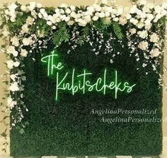 the krittscheks logo is displayed on a wall covered in white flowers