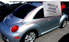 a silver car with a sign on it's back window that says beetle juice goes here