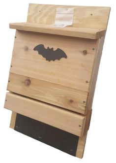 a wooden beehive with a bat painted on the top and bottom part in black