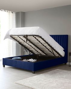 a bed with a blue headboard and foot board in a room next to a window