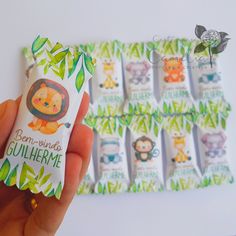 a hand holding a small package of toothpaste with jungle animals on the front