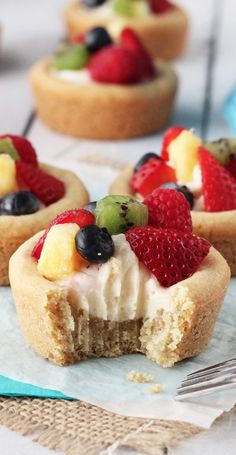 small desserts with fruit on top are sitting on a plate