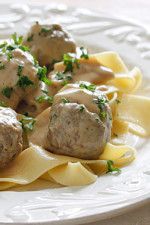 some meatballs and pasta on a white plate