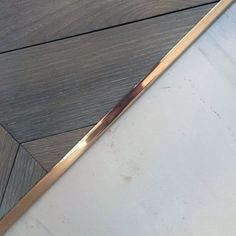 a close up of a wooden floor with a metal handle on it's end