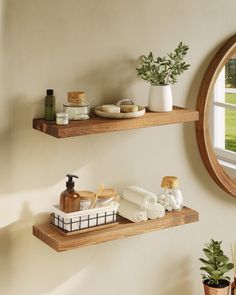 two wooden shelves with towels and soaps on them in front of a round window