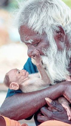 an old man holding a baby in his arms