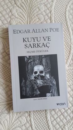 a book on the bed with an image of a skull in it's center