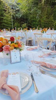 the table is set with flowers and place settings