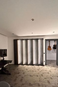 an empty room with guitars hanging on the wall