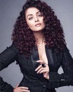 an image of a woman with curly hair posing for a magazine cover photo in black