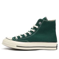 a pair of green converse sneakers with white laces