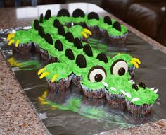 cupcakes with green frosting and black icing shaped like a crocodile's head