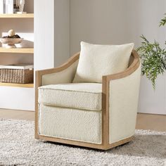 a white chair sitting on top of a rug next to a book shelf