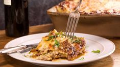 a plate with lasagna and a bottle of wine