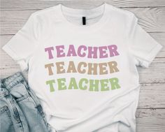 a t - shirt that says teacher teacher on it next to jeans and a pair of shoes