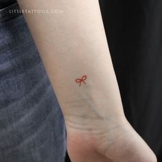 a small bow tattoo on the wrist