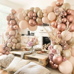 a living room filled with lots of balloons and flowers on top of a wooden table