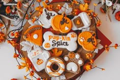 some decorated cookies are on a plate with orange and white decorations in the shape of pumpkins