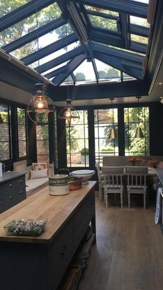 an open kitchen with wooden floors and black walls, along with lots of windows on the ceiling