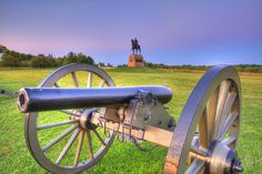 an old cannon sitting on top of a lush green field