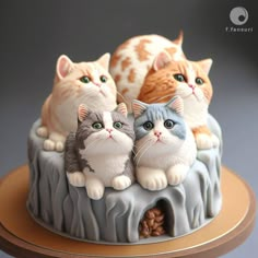 three cats sitting on top of a cake