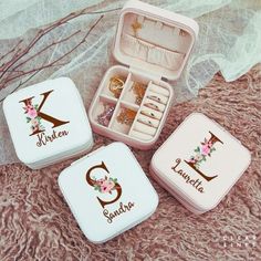 three personalized jewelry boxes sitting on top of a bed