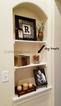 a shelf with candles and pictures on it