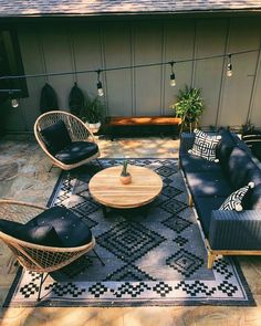 an outdoor living room with black and white furniture