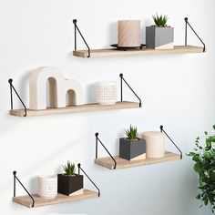 three wooden shelves with plants and decorative objects on them