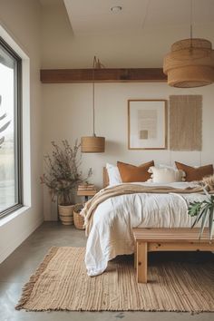 a bed sitting next to a window in a bedroom under a hanging light above it