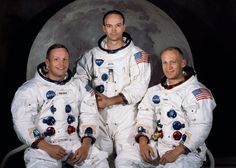 three men in white spacesuits standing next to each other