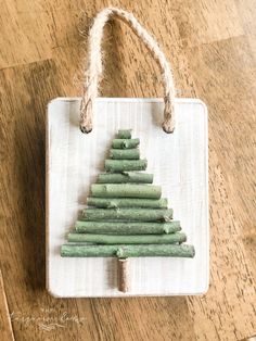 a small christmas tree made out of green beans on a white board with twine