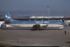 an airplane is parked on the tarmac in front of some hangars and buildings