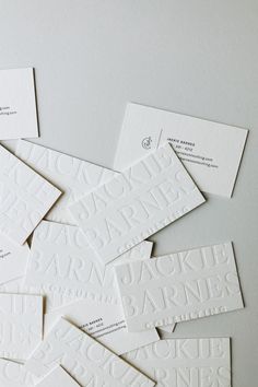 white business cards laid out on top of each other with black and white letters in the middle