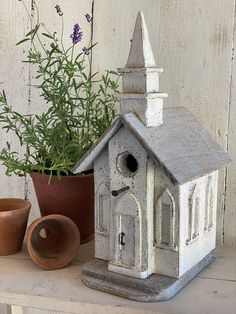 a bird house next to a potted plant