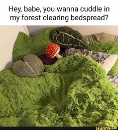 a bed covered in green fluffy blankets and pillows